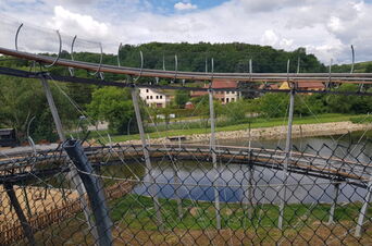 Pohled na konstrukci spirály bobové dráhy umístěnou u vodní plochy | Jízda na bobové dráze